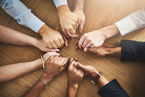 
                Acht Hände umfassen sich
            