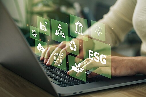 
                Person schreibt auf Laptop, aus dem Symbole wie ESG, CO2 etc. aufsteigen.
            