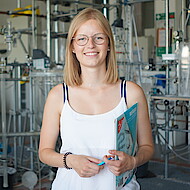 
                                Female student standing in a chemistry lab
                            