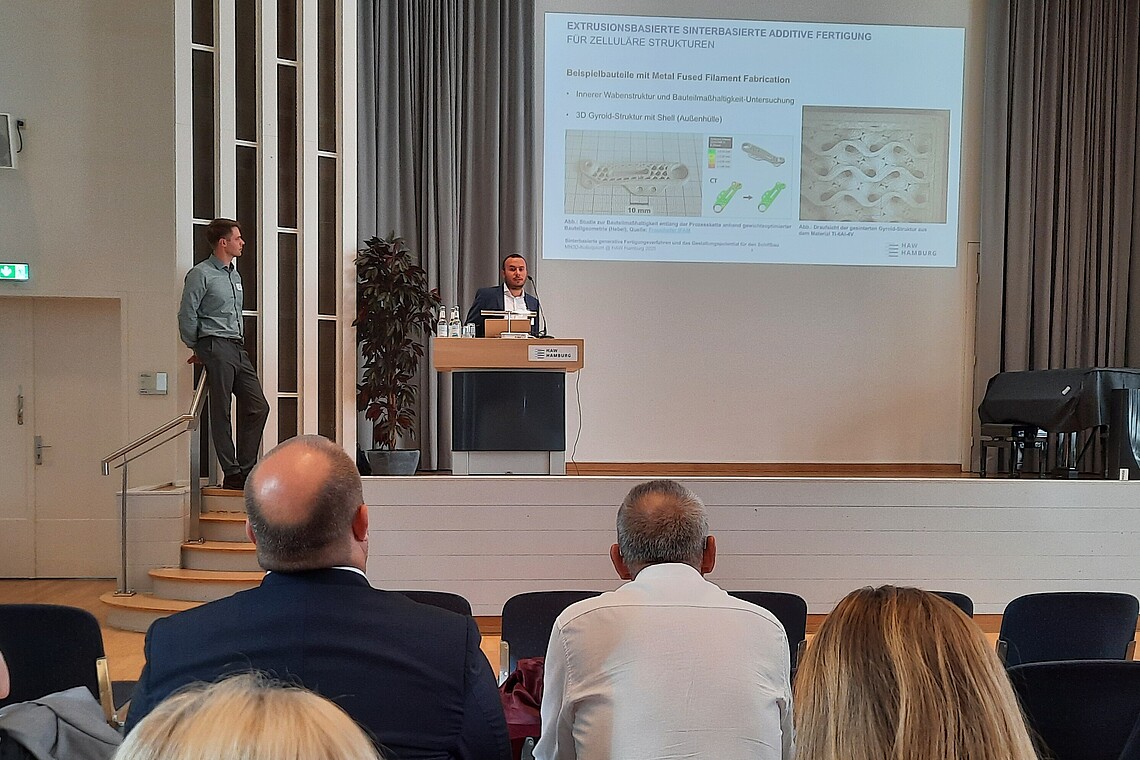 Die beiden Vortragenden auf der Bühne.