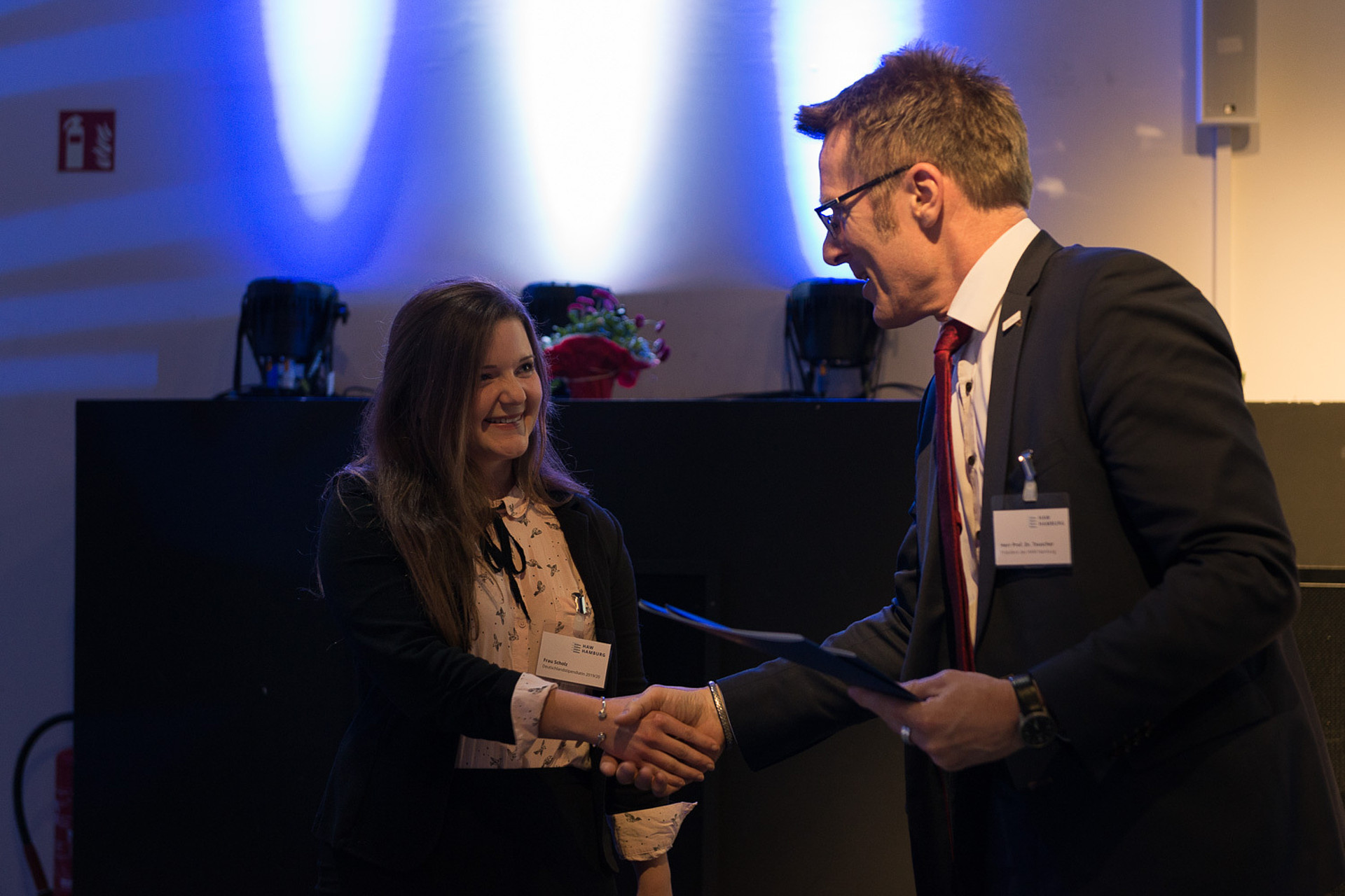 
                                                Hochschulpräsident der HAW Hamburg, Prof. Dr. Micha Teuscher überreicht einer Deutschlandstipendiatin ihre Urkunde
                                            