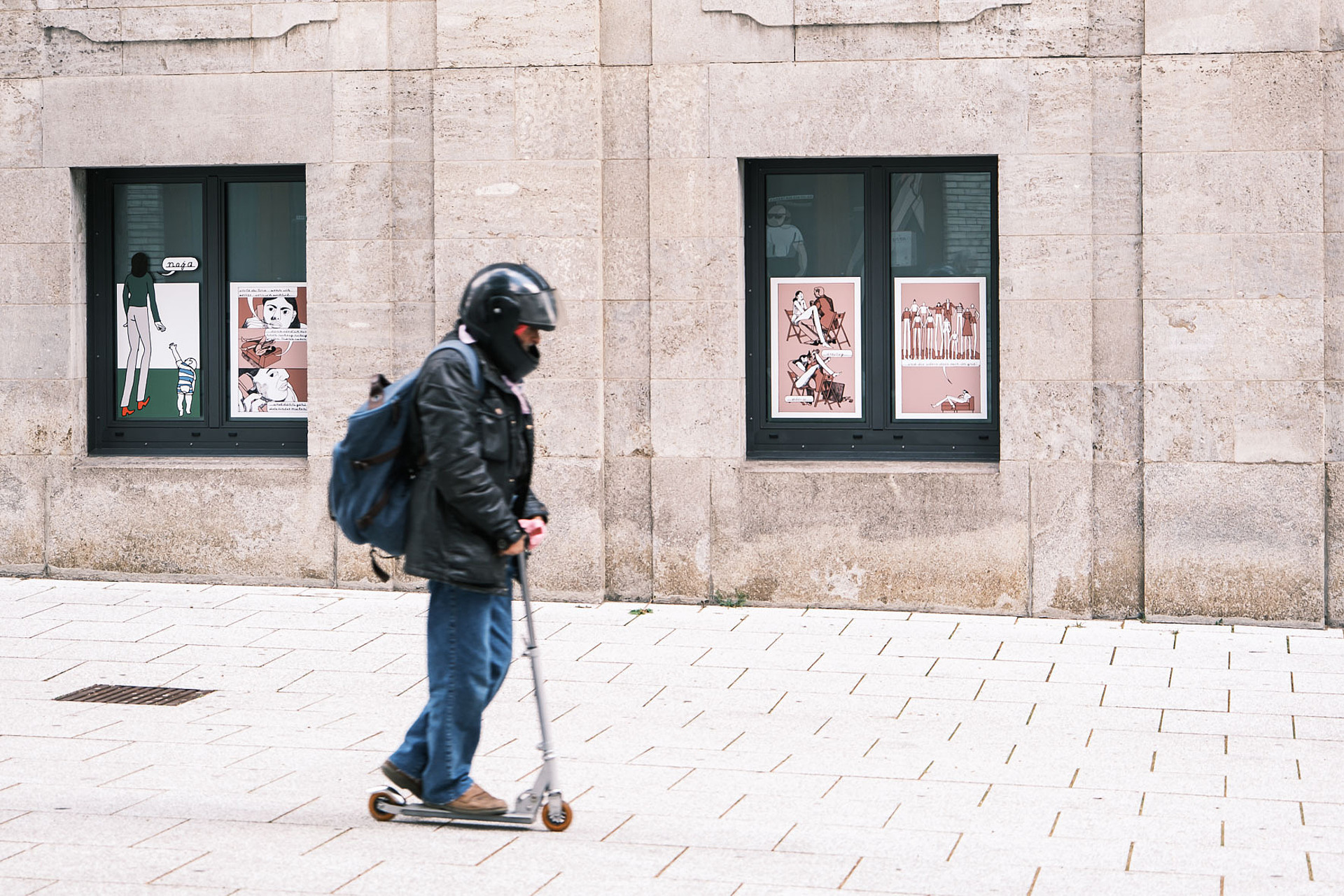 
                                                Eine Person fährt mit einem Roller am Comic-Aisschnitt von Mia Oberländer vorbei.
                                            