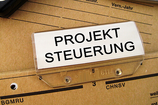 Projektmanagement im öffentlichen Sektor
Aktenordner mit der Aufschrift "Projektsteuerung"