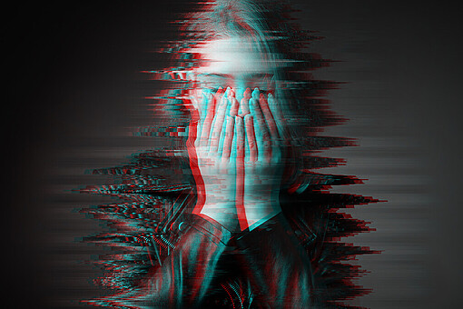 
                Verwaschenes Bild einer jungen Frau mit den Händen vor dem Gesicht
            