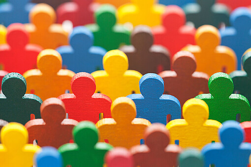 Diversity Management
Viele verschiedenfarbene Figuren stehen eng beieinander.