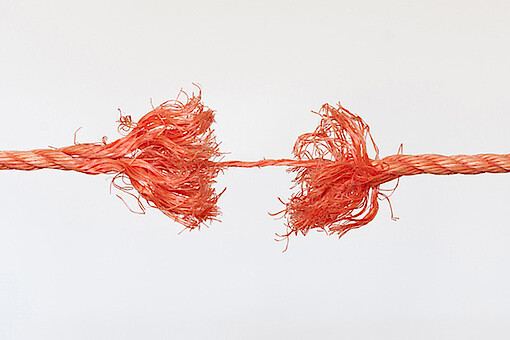 
                Ein rotes Seil ist in der Mitte zerrissen und wird an einem Faden zusammengehalten.
            